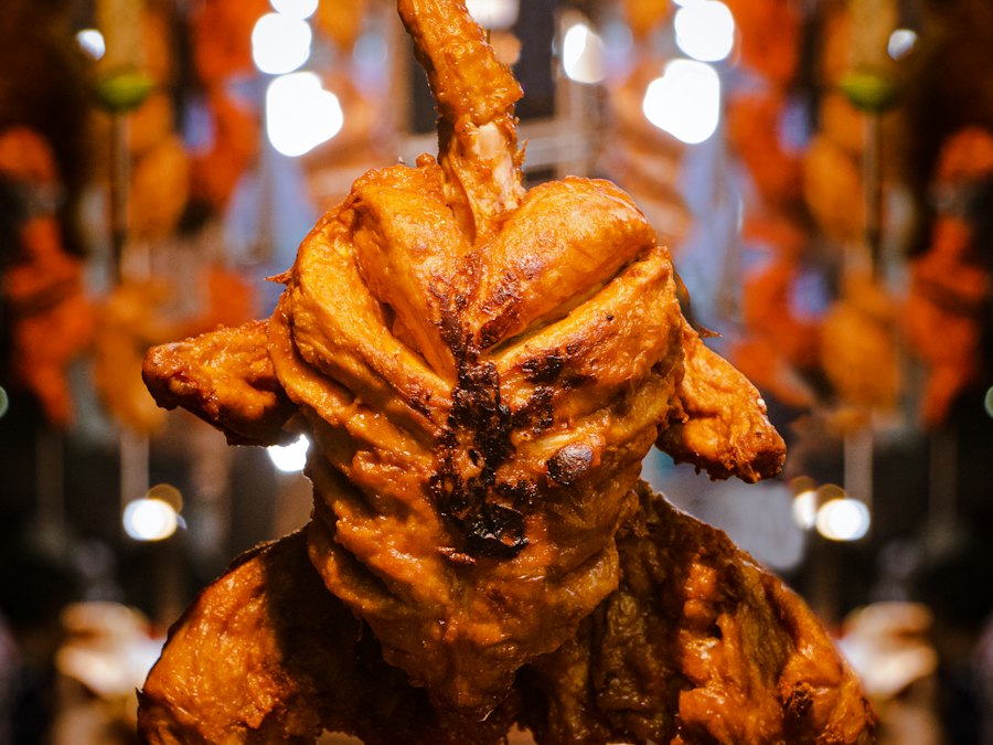 Whole tandoori chicken on a skewer